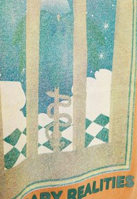 Tričko s grafickým designem v zelených a modrých barvách, zobrazující symbol kaduceus na pozadí oblaků a kostkovaném vzoru.
