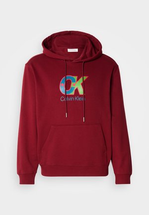 Bordo bombažna kapuca s sprednjim kengurujskim žepom, kapuco z vrvico in pisanim logotipom "OK", ki ima modre in zelene poudarke.