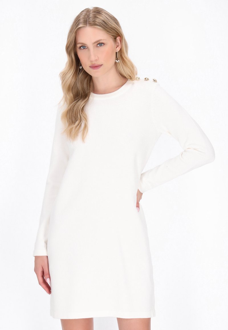 Abito bianco a maniche lunghe con scollatura rotonda e quattro bottoni decorativi sulla spalla. Tessuto morbido con una vestibilità comoda.
