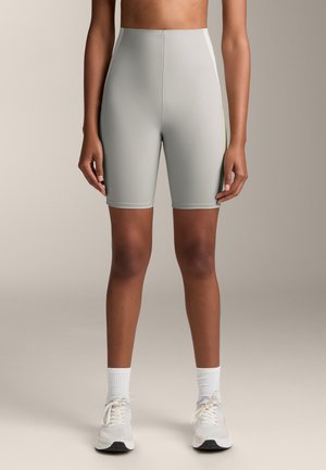 Shorts da ciclismo a vita alta, di colore grigio chiaro, realizzati in materiale elasticizzato. Presentano una superficie liscia e una striscia a contrasto sul lato.