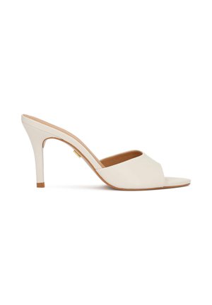 Bēšas krāsas atvērtpurnains apavs ar plānu augstu papēdi un gludu ādas augšdaļu, attēlots sānskatā uz baltas fona.