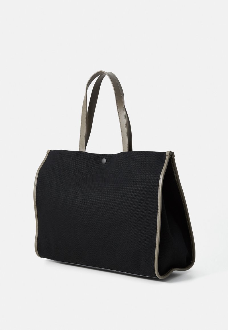 Borsa tote in tela nera con accentuazione grigia. Presenta un design semplice, angoli arrotondati e due manici robusti. Chiusura a scatto nella parte superiore.