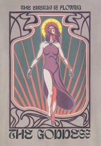 Grafisches T-Shirt mit einer zentralen Figur in einem fließenden lila Kleid vor einem grün-roten Sonnenstrahlen-Hintergrund, mit Text darüber und darunter.