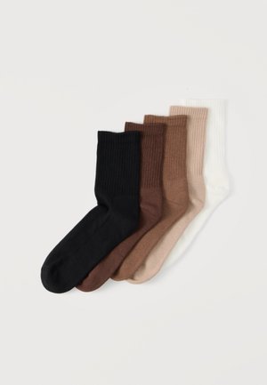 Cinq paires de chaussettes côtelées mi-hautes, disposées en chevauchement, de couleurs noir, brun foncé, brun moyen, beige et blanc, sur un fond blanc.