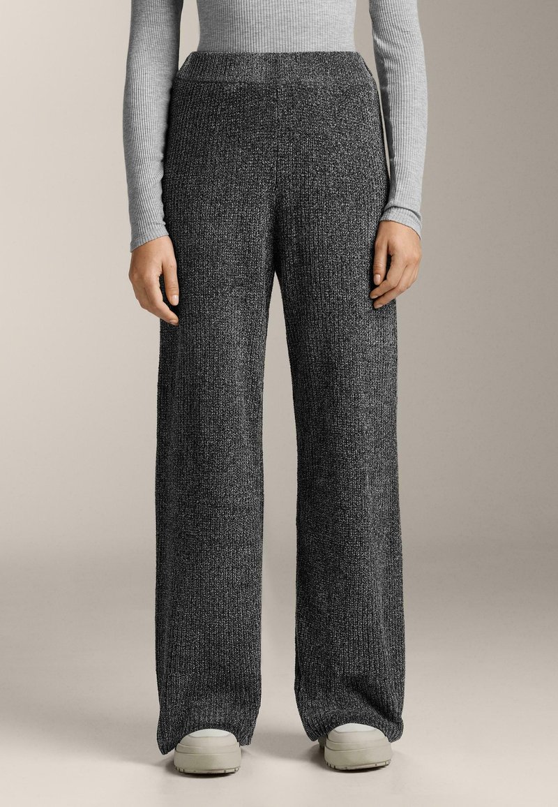 Široké nohavice vyrobené z textúrovaného, tmavošedého pleteného materiálu s vysokým pásom. Majú uvoľnený strih a hladký pás.