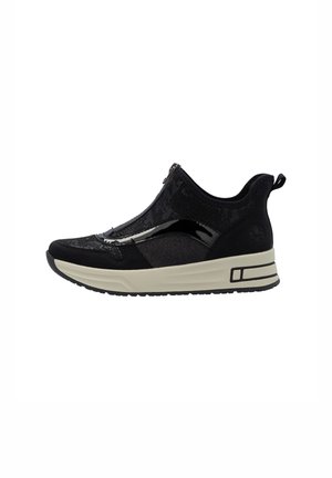 Sort slip-on sneaker med tekstureret stof, blanke accenter, beige tyk sål og trækstrop ved hælen vendt mod højre på hvid baggrund.