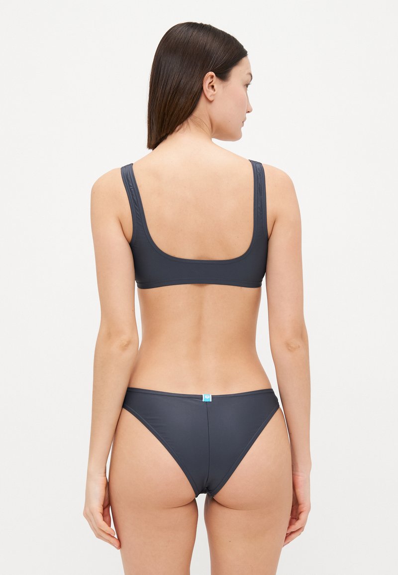 Dunkelgraues Bikini-Set mit einem Top mit Rundrücken, breiten Trägern und minimalistisch geschnittenen Unterteilen. Glatte Textur und klassische Designelemente sind vorhanden.