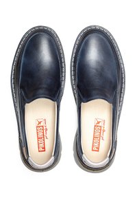 Zapatos de piel tipo mocasín en un azul marino oscuro con acabado suave, detalles de costura y una plantilla acolchada. Marca visible en la plantilla.