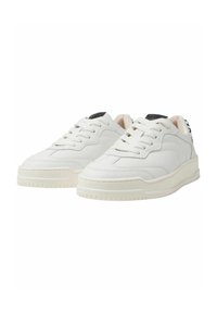 Baskets en cuir blanc avec une surface texturée, bout rond et détails perforés. Semelle en caoutchouc épaisse avec un logo discret sur la languette.
