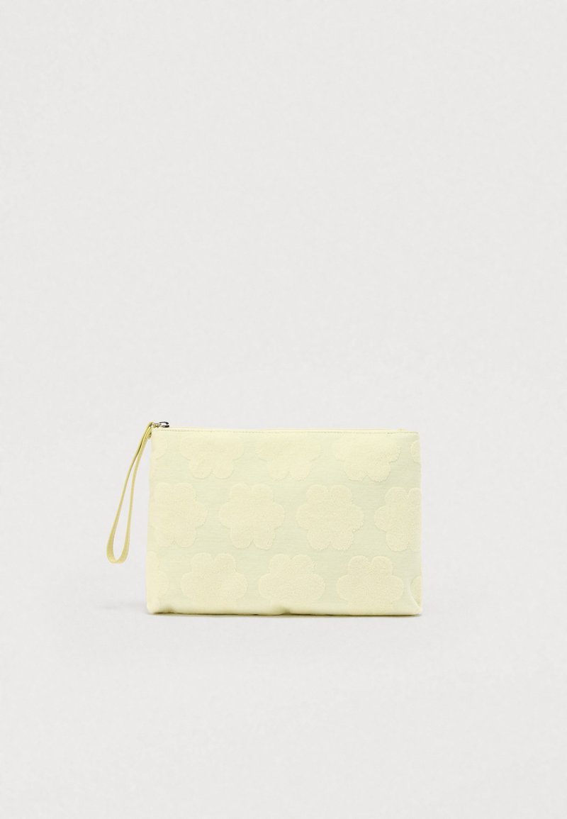 Κίτρινη θήκη με λουλουδάτο σχέδιο, κατασκευασμένη από μαλακό ύφασμα, με κλείσιμο με φερμουάρ και λουράκι χειρός. Υφή με λουλουδάτο σχέδιο στην επιφάνεια.