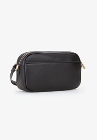 Borsa rettangolare in pelle nera con una texture liscia. Presenta una cerniera dorata e una tracolla laterale. La parte anteriore ha una tasca piatta per ulteriore spazio di archiviazione.