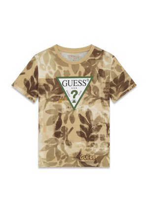 Maglietta a maniche corte beige e marrone con motivo a foglie e logo triangolare Guess con bordo verde e punto interrogativo al centro sul davanti.