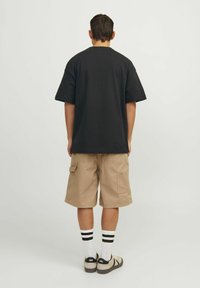 Sort kortærmet t-shirt, beige cargo shorts, hvide sokker med sorte striber og sorte sko. Simpelt design, afslappet pasform, bomuldsstof.