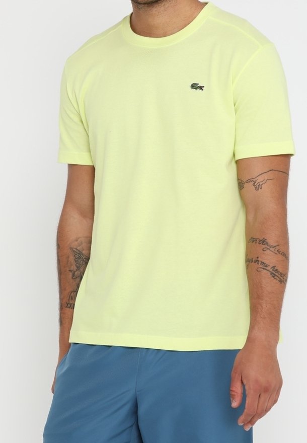 Limetkově zelené tričko s krátkým rukávem z měkké látky, s kulatým výstřihem a malým vyšitým logem na levé hrudi.