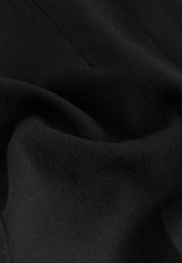 Černá tkanina s hladkým texturem a jemným leskem, s jednoduchým, jednobarevným designem. Materiál vypadá měkce a pružně, vhodný pro oděvy.