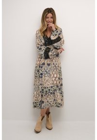 Robe maxi florale en tissu doux avec des manches longues, des accents en dentelle noire et des nuances de bleu, vert et beige.