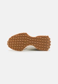 White sneaker sole with a textured brown rubber outsole featuring circular patterns for grip. Rounded shape, lightweight design, and smooth finish.