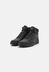 Zapatillas altas negras de cuero sintético, con un cuello acolchado, detalles texturizados y una suela de goma maciza con patrones de tracción.