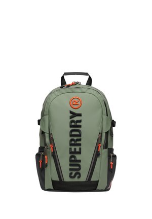 Grøn og sort rygsæk med flere lynlåslommer, orange lynlåstræk og stort lodret "SUPERDRY" logo på forsiden.