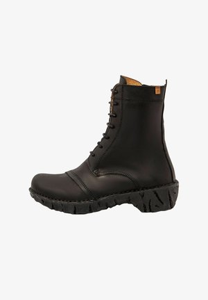 Botín negro de cuero con cordones, suela de goma texturizada y forro interior marrón, presentado en perfil lateral sobre fondo blanco.