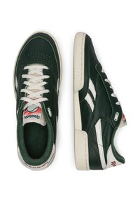 Tmavozelené tenisky Reebok s bielymi pruhmi a šnúrkami, bielymi podrážkami a červeným logom na päte a jazyku, zobrazené z bočného a horného pohľadu.