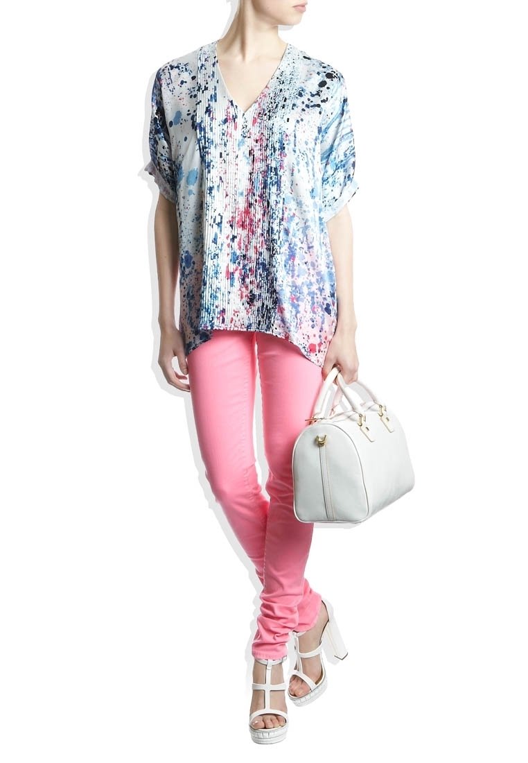 Blouse à manches courtes multicolore avec motif éclaboussé ; jean skinny rose ; sac à main blanc avec des accents dorés ; sandales à plateforme blanches.