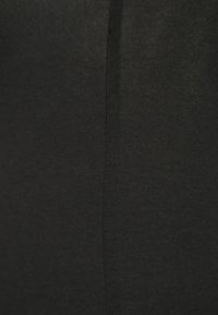 Melnas kokvilnas audums ar gludu, mīkstu tekstūru. Iekļauj vertikālu šuvi, kas stiepjas cauri centram, radot tīru, vienkāršu dizainu.