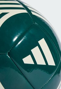 Balón de fútbol verde con una textura brillante, que presenta patrones de rayas blancas y un distintivo logo blanco con tres rayas en ángulo.