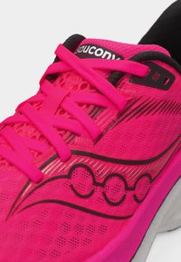 Φωτεινό ροζ παπούτσι για τρέξιμο Saucony με μαύρο λογότυπο, επάνω μέρος από δίχτυ και κορδόνια σε ταιριαστό ροζ χρώμα δεμένα πάνω από τη γλώσσα.