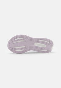 Suola della scarpa con una superficie in gomma viola chiaro, caratterizzata da un motivo testurizzato, scanalature di flessibilità e accenti bianchi per trazione e supporto.