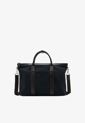 Bolso de viaje grande negro con asas de cuero, correa ajustable para el hombro y cierres metálicos plateados sobre fondo blanco.