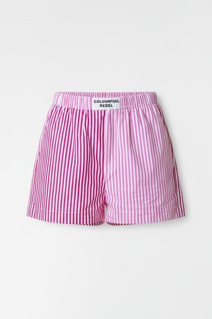Stripete shorts i rosa og lilla nyanser, med elastisk midjebånd og en etikett med teksten "COLOURFULL REBEL." Lett stoff.