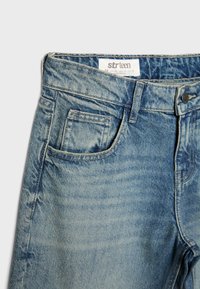 Blaue, ausgewaschene Jeans im Taillenbereich mit Vordertasche, Münztasche, Gürtelschlaufen und Knopfverschluss, Größe 36 von der Marke Strteen.