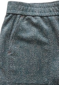 Geweven stofbroek in teal met een subtiele textuur en lichte beige accenten, een zijzak en een knoopdetail.
