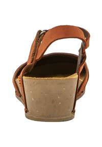 Sandalia de cuero marrón con tacón de cuña de madera y goma, que cuenta con correas ajustables y una plantilla texturizada para mayor comodidad.