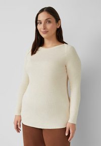 Langdlijf top van beige geribd materiaal, met een ronde hals, slim fit ontwerp, lichtgewicht textuur, gecombineerd met bruine broek.