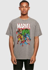 Šedé oversized tričko vyrobené z bavlny s předním grafickým potiskem superhrdinů Marvel v živých barvách, včetně Hulka, Iron Mana a Spider-Mana.