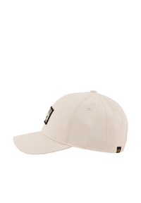 Kapa za bejzbol iz kremaste bombažne tkanine; ima rahlo ukrivljen vizir, našito logo nalepko spredaj in ventilacijske luknje na vrhu.