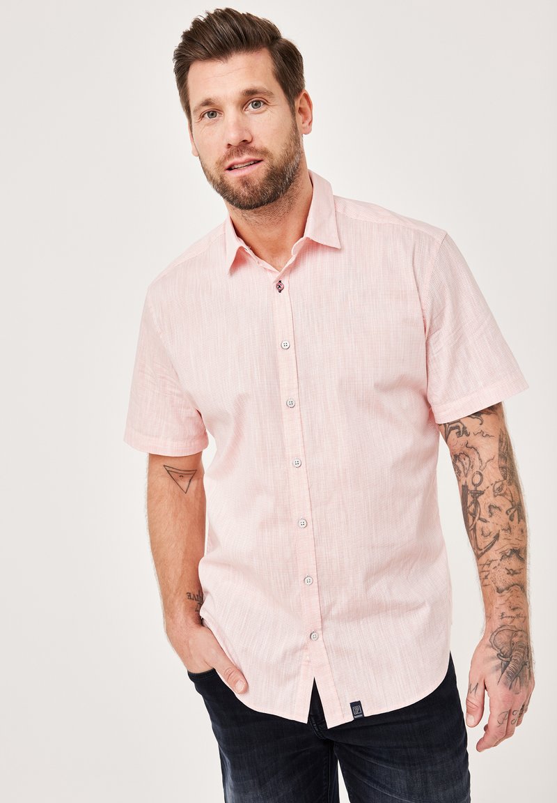 Kurzärmeliges, hellrosa Hemd mit Knöpfen und strukturiertem Muster, ausgestattet mit weißen Knöpfen und einem kleinen Logoschild am Saum.