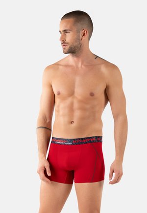 Boxer briefs rouges avec une ceinture grise portant le texte "AITHER SPORT" ; design ajusté avec des détails de couture contrastés.