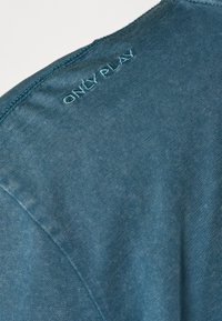 Tamsiai žalia trumpa rankovė marškinėliai su briaunotu tekstūru. Priekyje su siuvinėtu „ONLY PLAY“ ant kaklo; bešiūlė pečių konstrukcija.