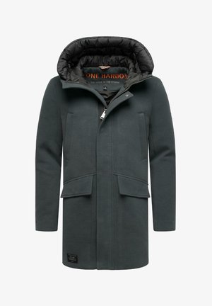 Tume roheline villane jope, millel on tihedalt tikitud must kapuuts ja vooder. Omab kahte esimest taskut ja brändi märk alläärselt.