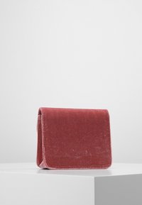 Borsa in velluto rosa polvere, con un semplice design rettangolare e una patta piegata. Texture morbida e bordi puliti, aspetto minimalista.