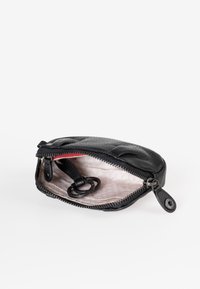 Borsetta in pelle nera con superficie testurizzata, chiusura con zip e interno chiaro dotato di un anello per le chiavi. Accent rosso all'interno.