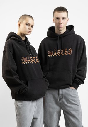 Zwarte hoodies met een oversized pasvorm, voorzien van een gestileerde oranje grafiek op de voorkant. Materiaal heeft een zachte textuur, met een voorzak en een verstelbare koord.
