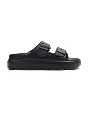 Sandalia negra tipo slip-on con suela gruesa y dos tiras ajustables con hebilla, diseñada para uso casual.