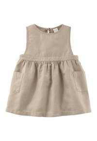Jasnobeżowa lniana sukienka z zaokrąglonym dekoltem, bez rękawów, z marszczonym dołem i dwoma przednimi kieszeniami. Zapięcie na plecach z kluczową dziurką.