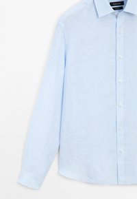 Camicia a righe blu chiaro realizzata in tessuto intrecciato. Presenta un colletto appuntito, maniche lunghe e chiusura frontale con bottoni bianchi.