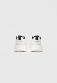 Adidași albi cu accente gri, material texturat, guler căptușit și un logo pe toc. Prezintă o talpă groasă pentru un suport îmbunătățit.