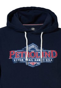 Sudadera azul marino con un gráfico frontal que dice "PETROLIND" en rojo y blanco, con cierre de cordón y una textura suave.